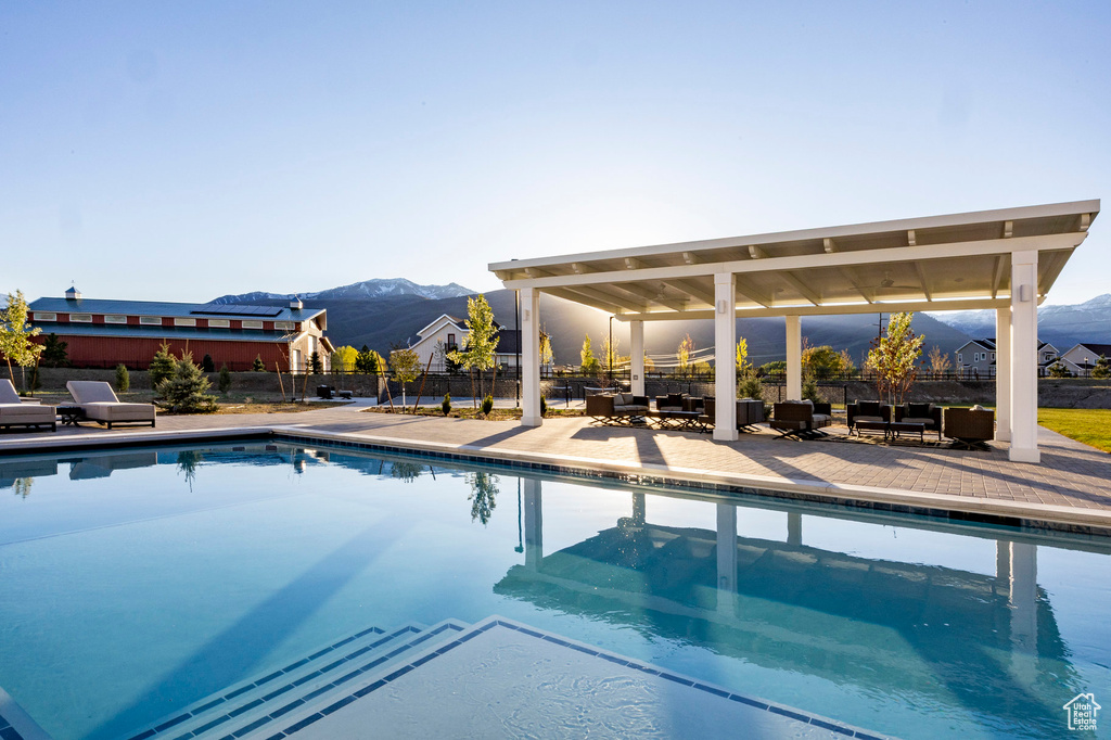 View of pool with a mountain view, fence, a patio area, and outdoor lounge area