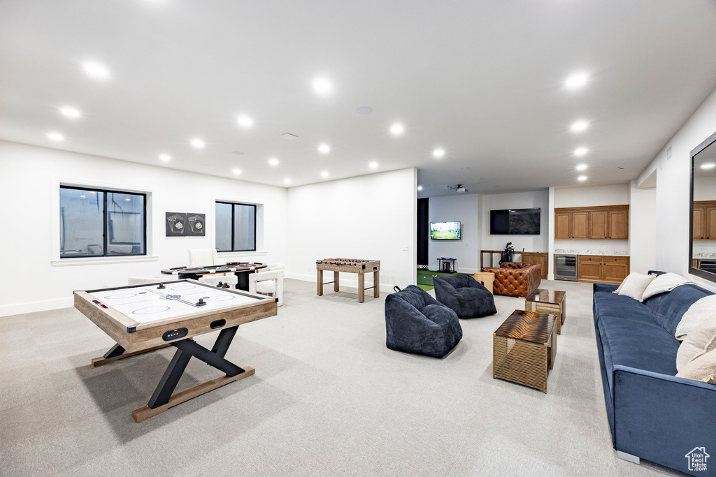 Recreation room featuring beverage cooler, recessed lighting, baseboards, and light carpet