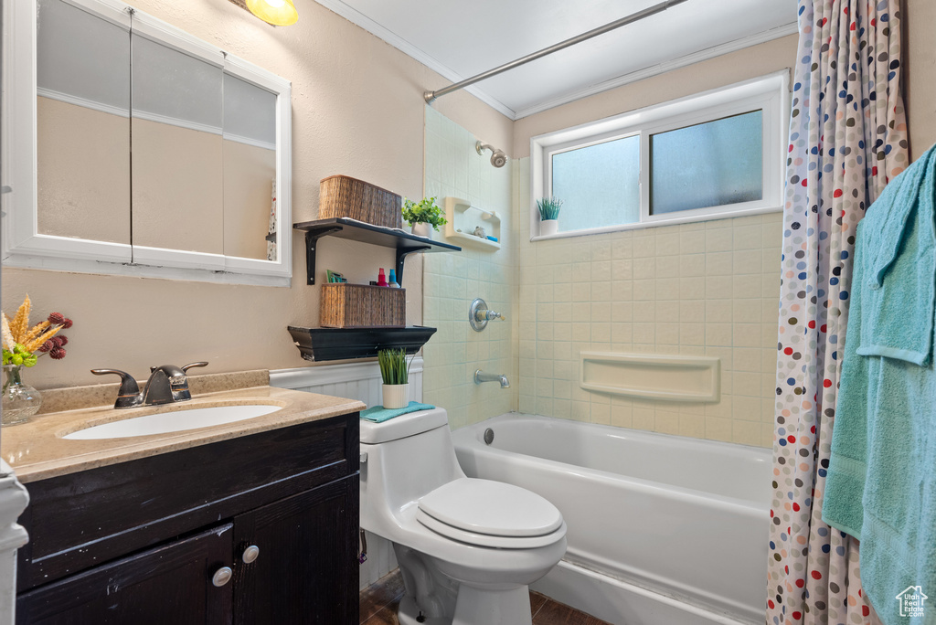 Bathroom featuring shower / bath combo, ornamental molding, toilet, and vanity
