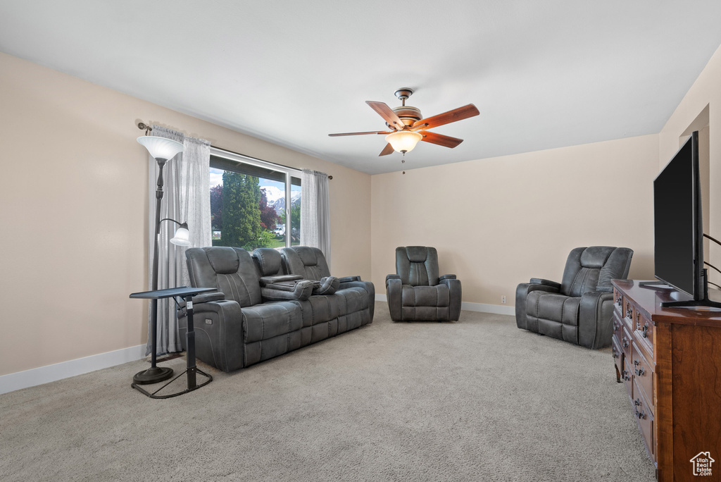 Living room with a ceiling fan, carpet floors, and baseboards