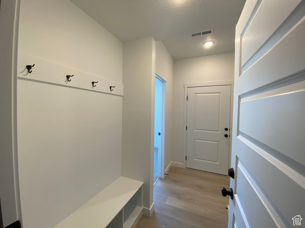 Mudroom featuring light wood-type flooring and baseboards