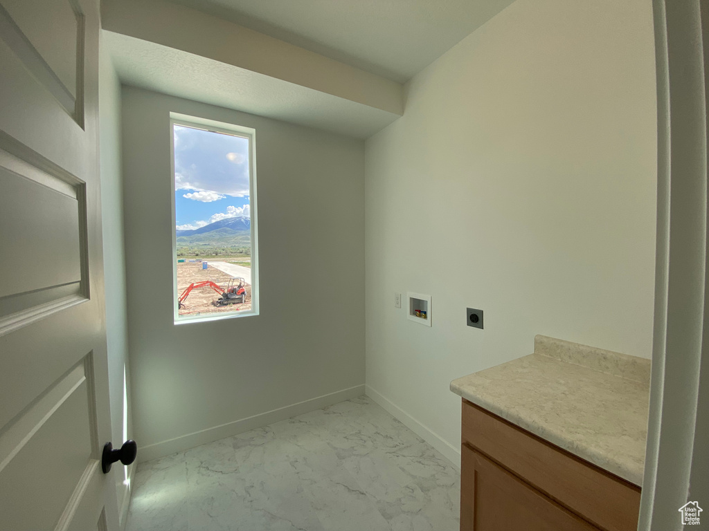 Laundry area with electric dryer hookup, washer hookup, baseboards, and light marble finish flooring