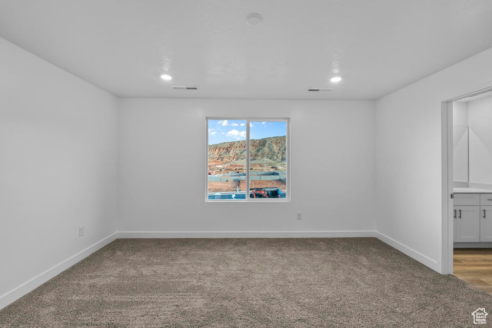 Unfurnished room featuring light carpet, baseboards, and recessed lighting