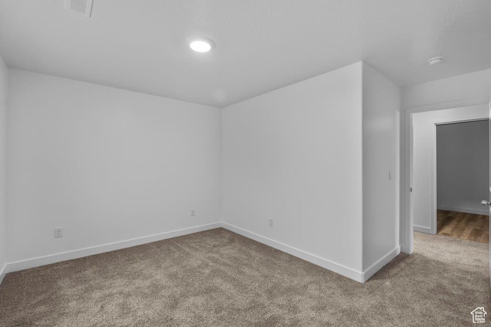 Carpeted empty room with baseboards
