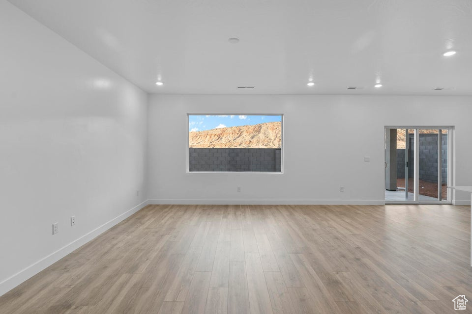 Empty room with light wood-style flooring, recessed lighting, and baseboards