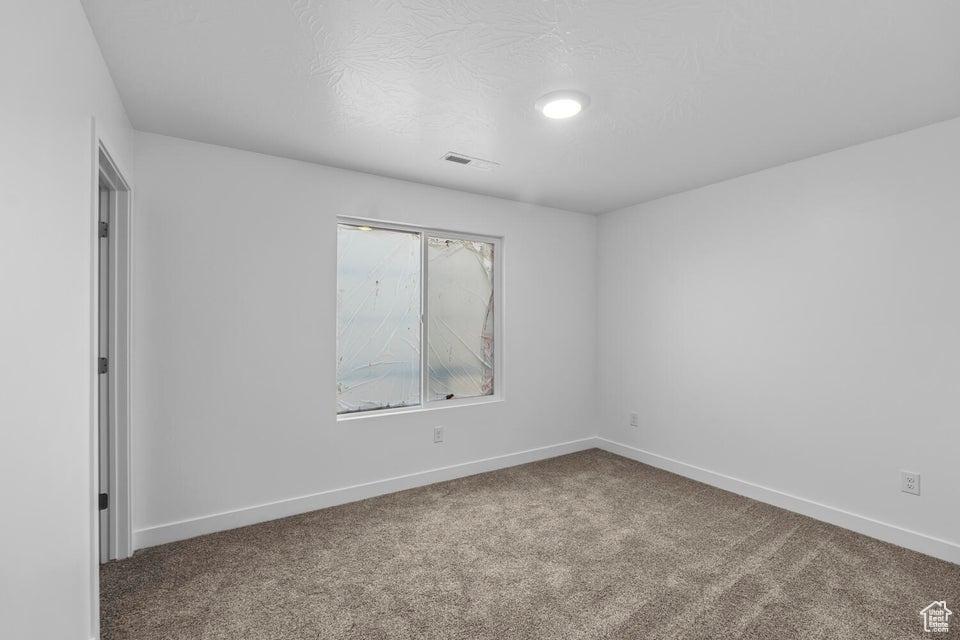 Empty room with carpet floors and baseboards