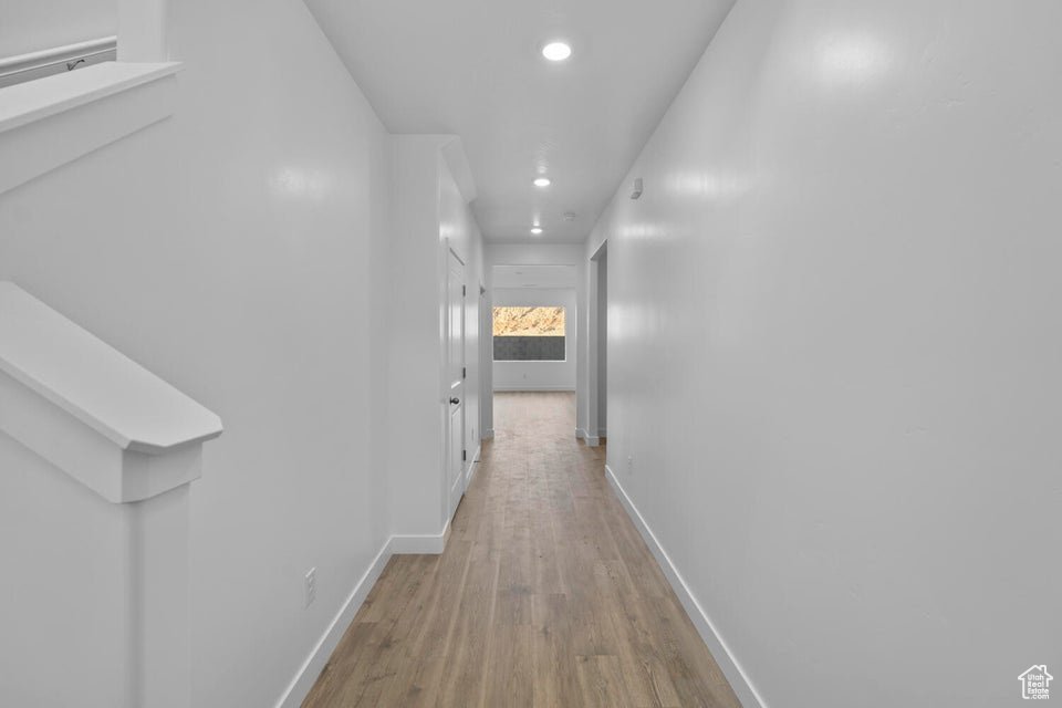 Hall with light wood-style flooring, recessed lighting, and baseboards