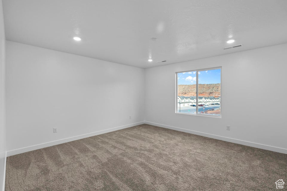 Carpeted spare room featuring recessed lighting and baseboards