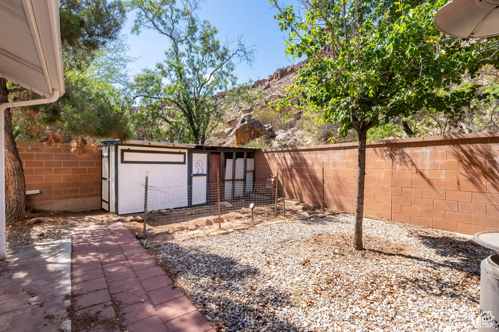Fenced backyard featuring an outdoor structure and a mountain view