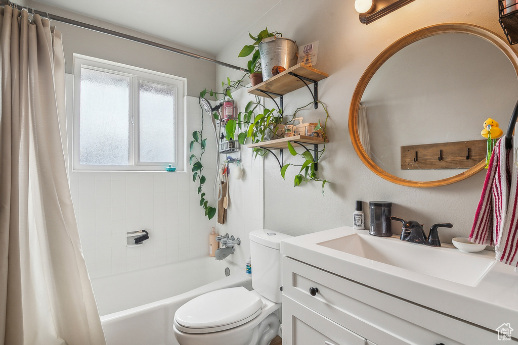 Full bathroom featuring toilet, vanity, and shower / bath combo with shower curtain