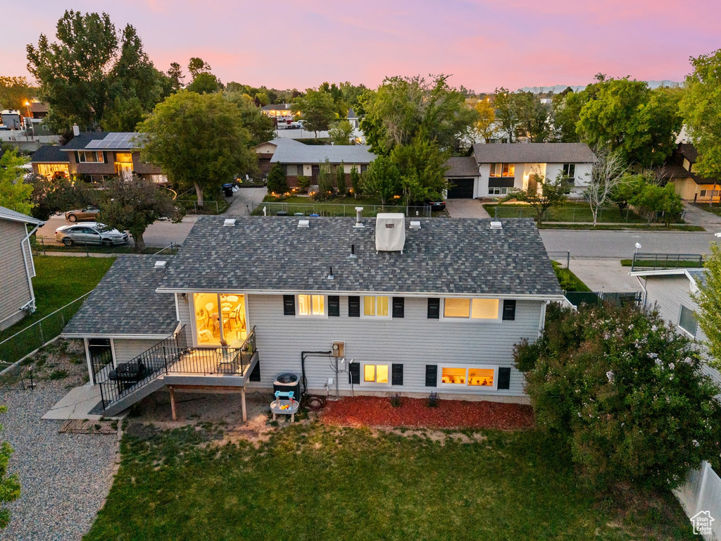 Rear view of property featuring a deck, a residential view, and a shingled roof