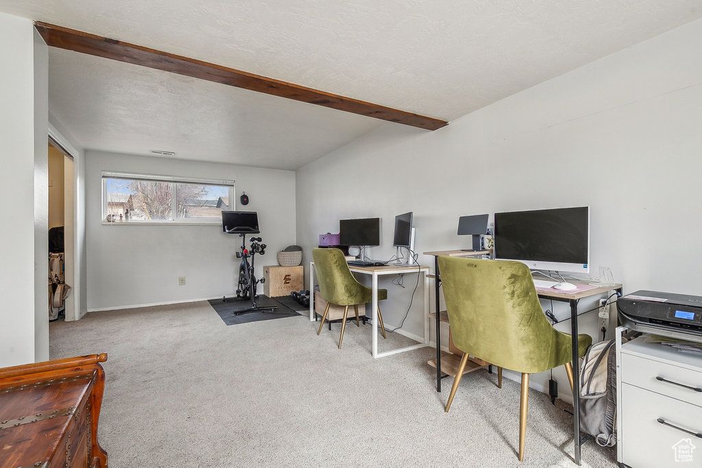 Office space featuring light colored carpet, beamed ceiling, and baseboards