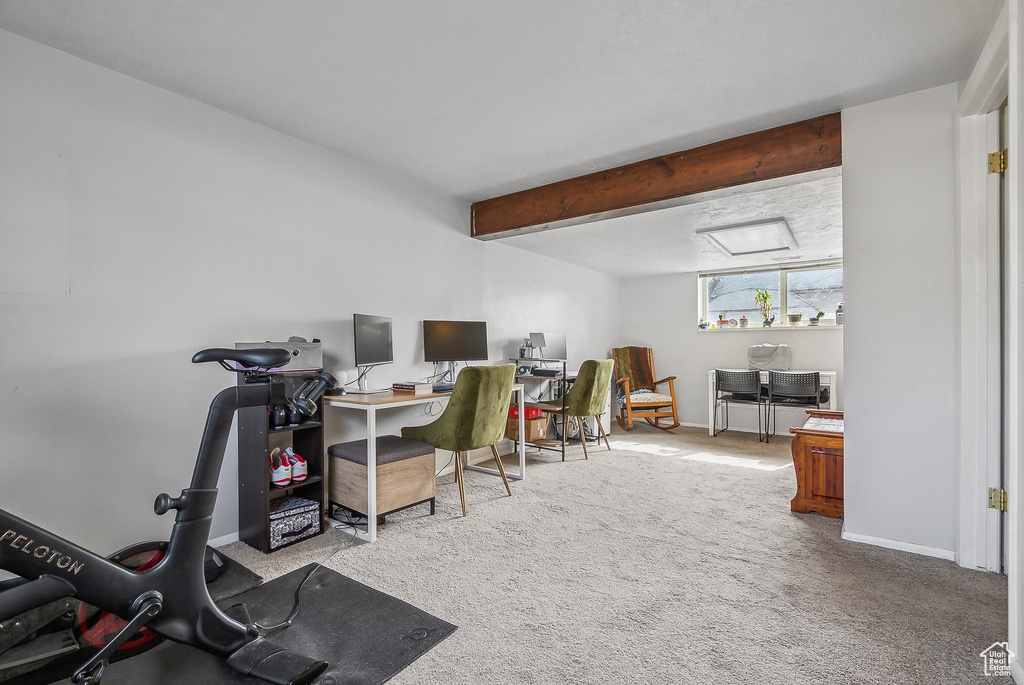 Carpeted home office with beamed ceiling and baseboards