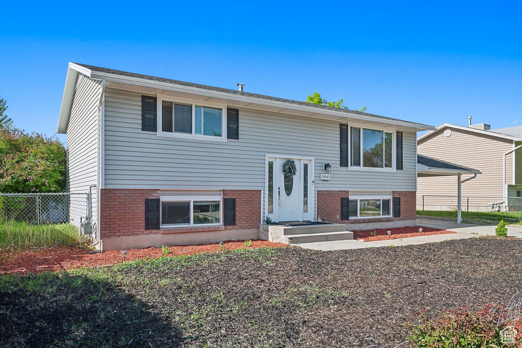 Bi-level home with brick siding and fence