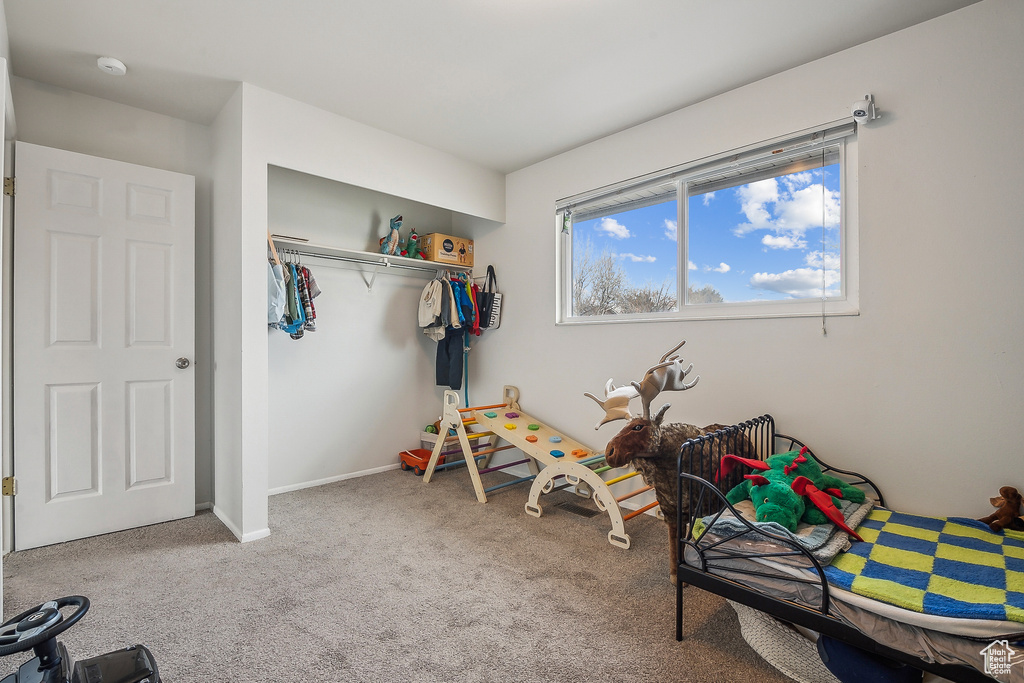 Bedroom with carpet flooring, a closet, and baseboards