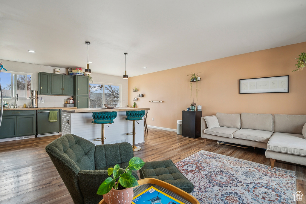 Living area with healthy amount of natural light, wood finished floors, recessed lighting, and baseboards