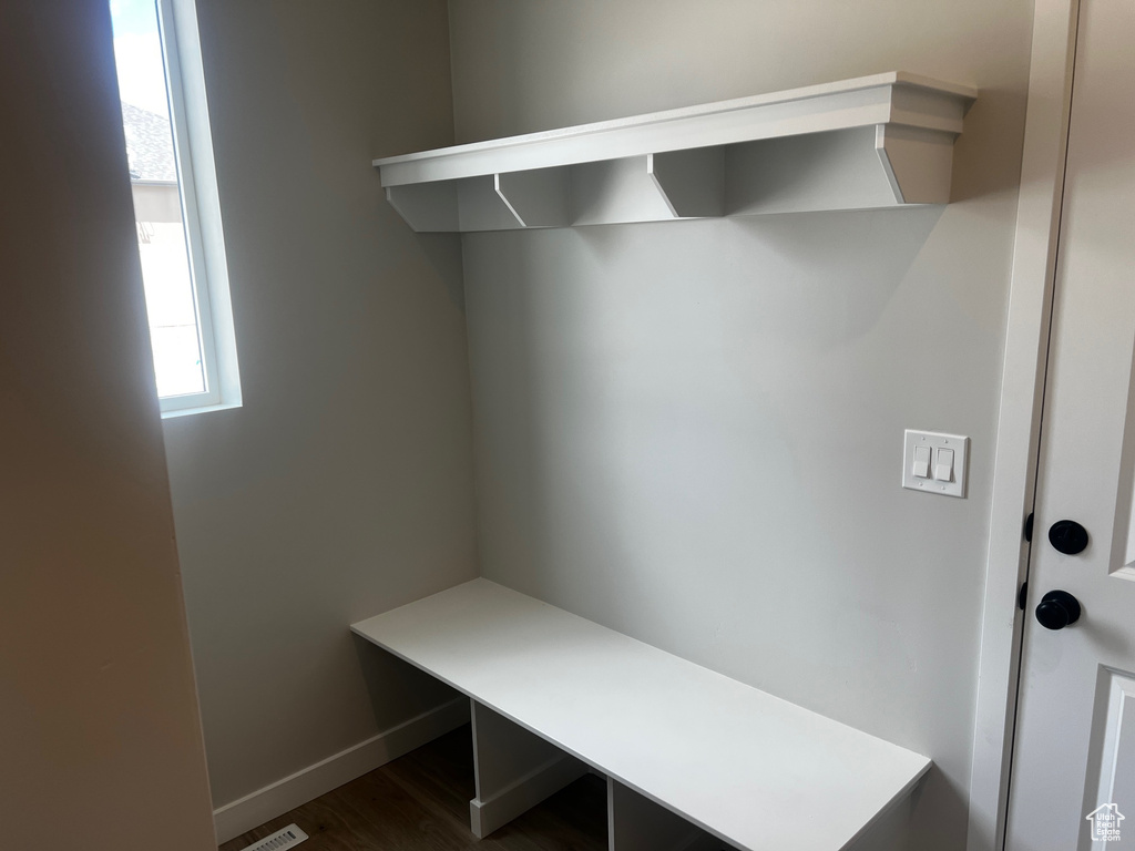 Mudroom featuring dark wood-style floors and baseboards