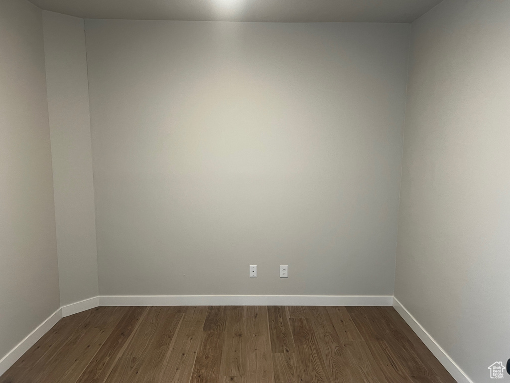 Unfurnished room with dark wood finished floors and baseboards