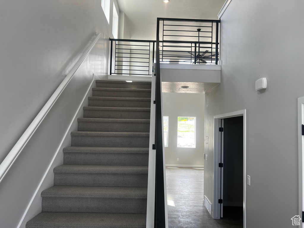 Staircase with a high ceiling and baseboards