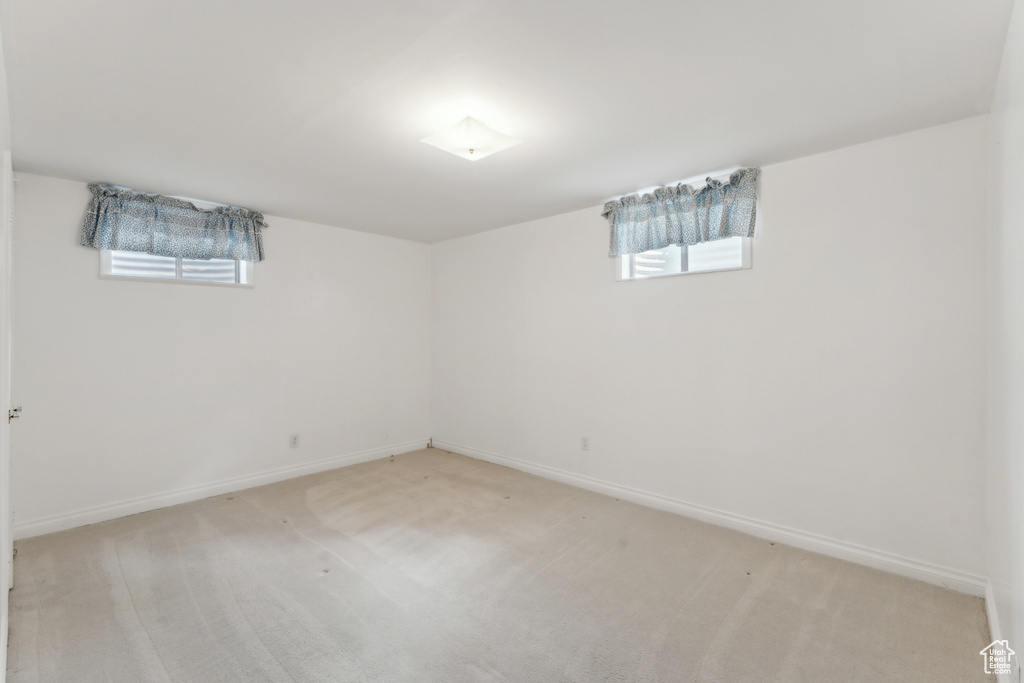 Below grade area featuring light colored carpet and baseboards