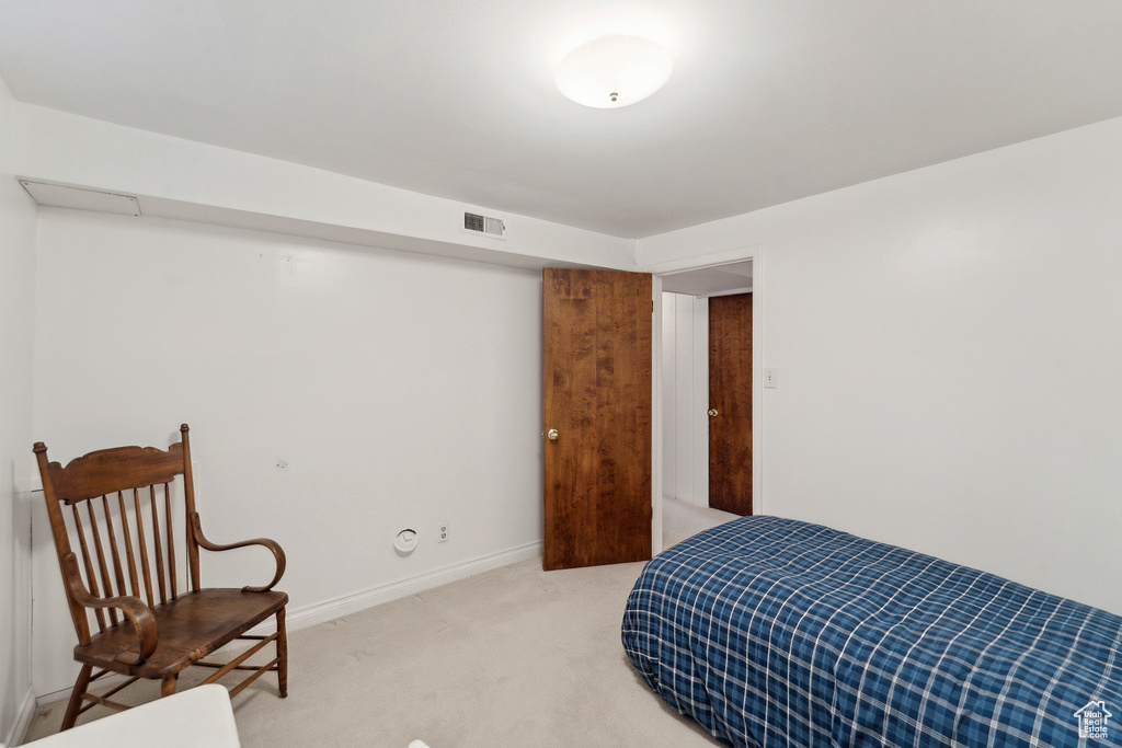Bedroom featuring light carpet and baseboards