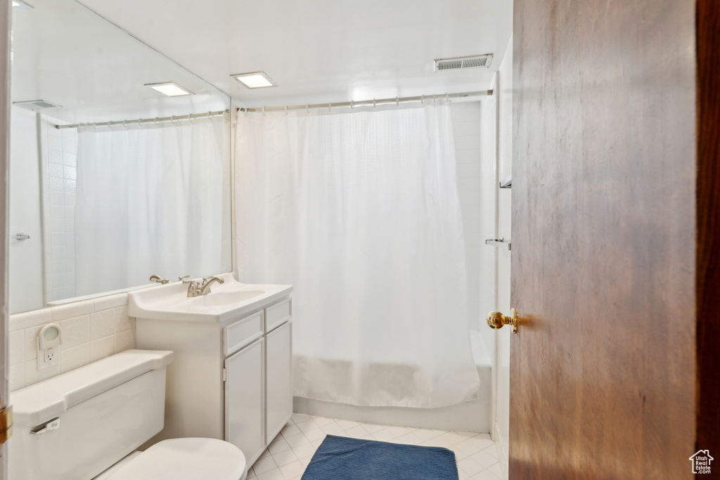 Full bath with tile patterned floors, toilet, shower / tub combo, and vanity