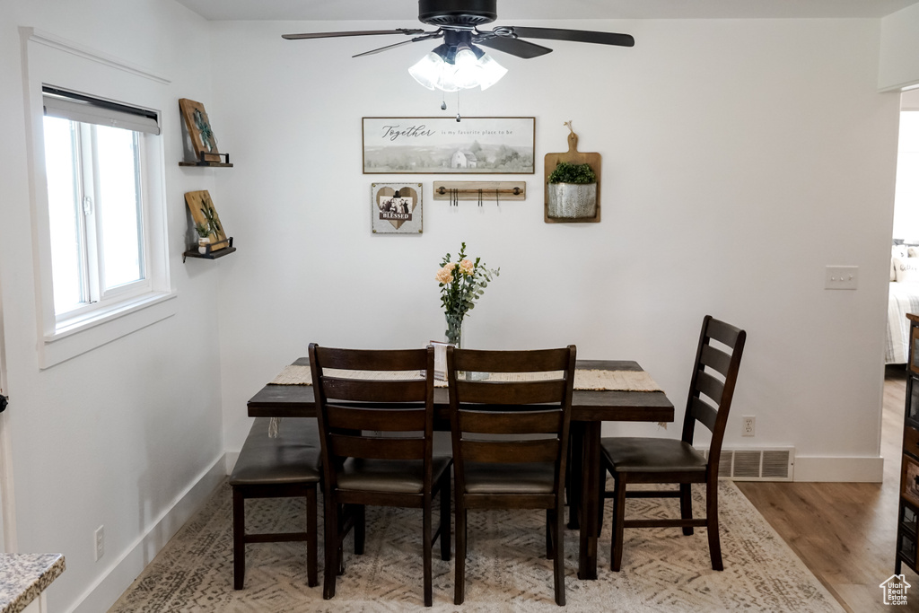 Dining area featuring a ceiling fan, baseboards, and wood finished floors