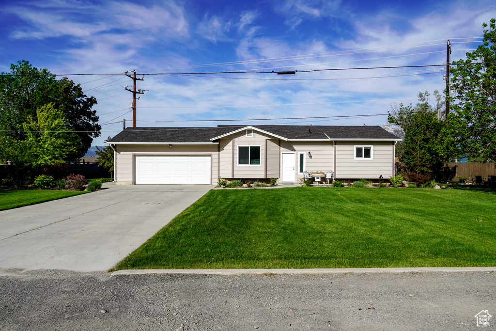 Ranch-style home with concrete driveway and an attached garage