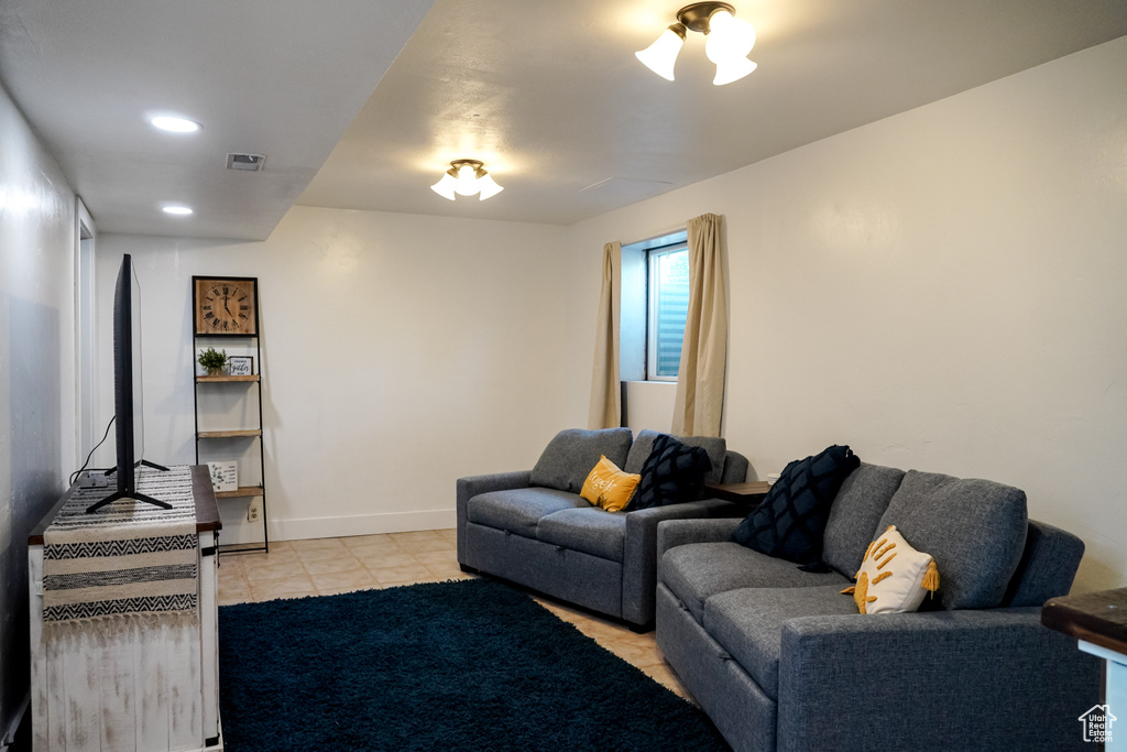 Living area with light tile patterned flooring, baseboards, and recessed lighting