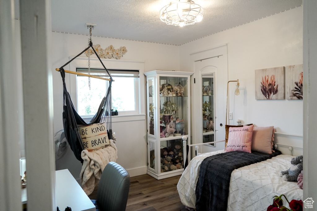 Bedroom with wood finished floors and a textured ceiling