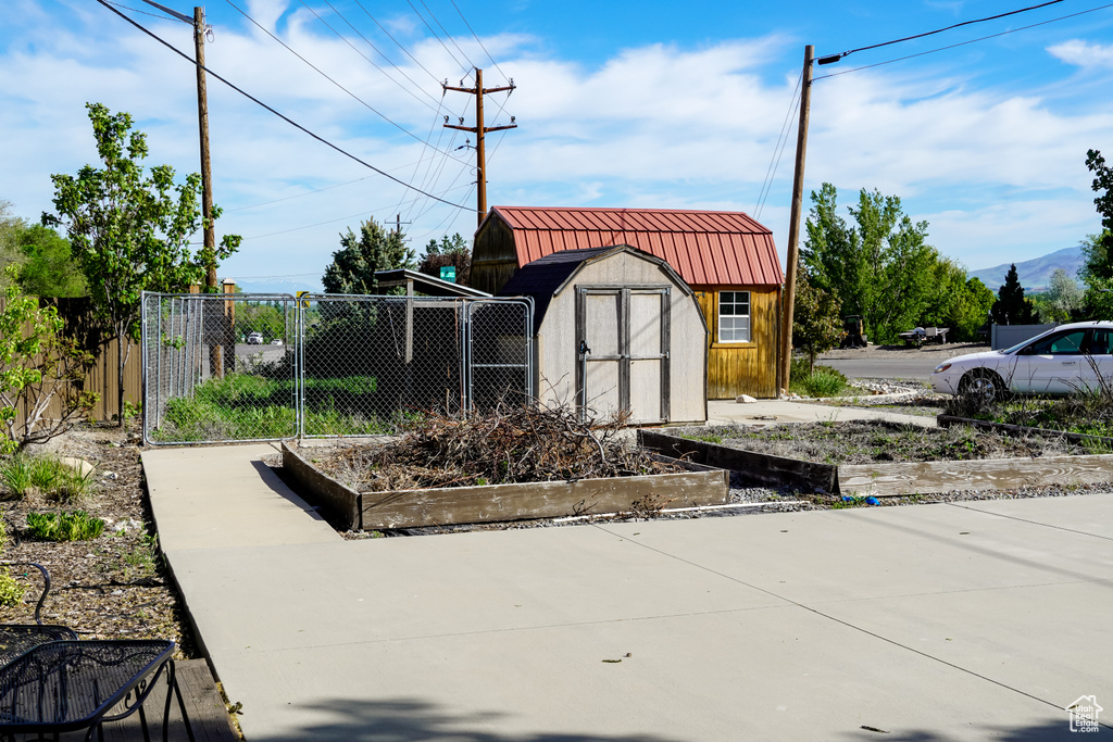 Surrounding community featuring a garden, a storage unit, fence, and an outbuilding