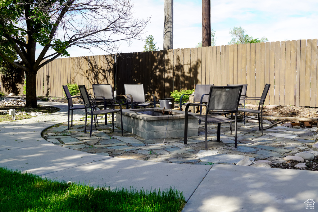 View of patio featuring fence and a fire pit