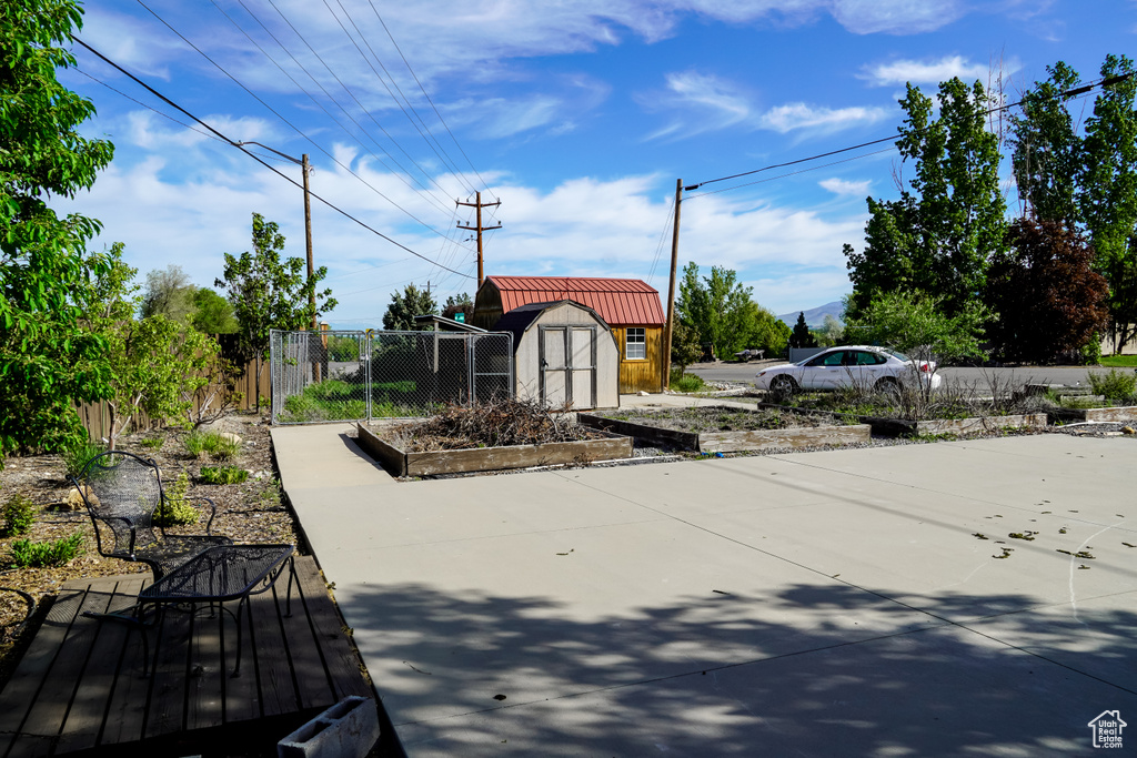 Exterior space featuring a storage unit, fence, and an outdoor structure