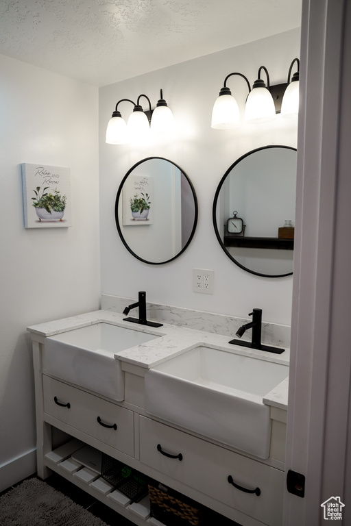 Bathroom with double vanity and a textured ceiling