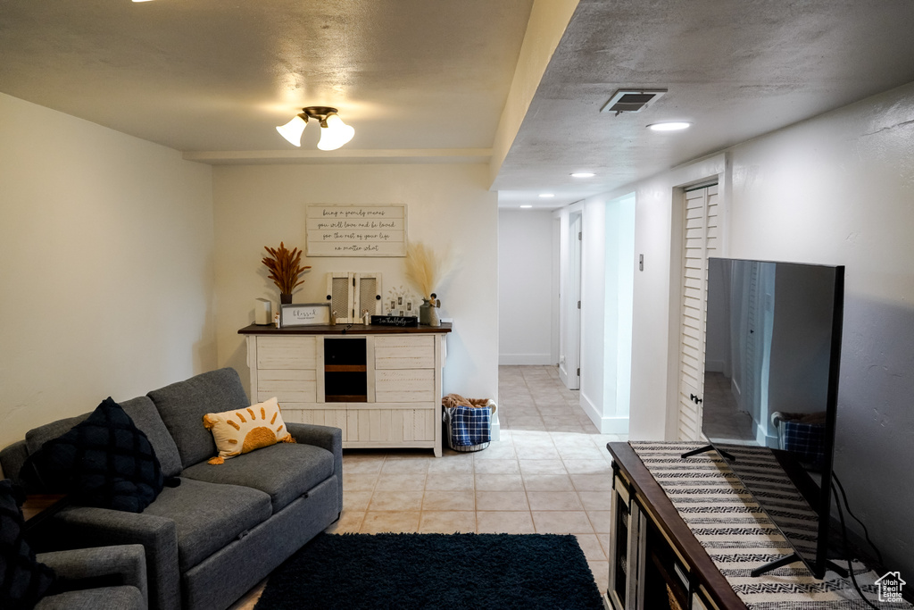 Living room featuring light tile patterned flooring, bar area, and recessed lighting
