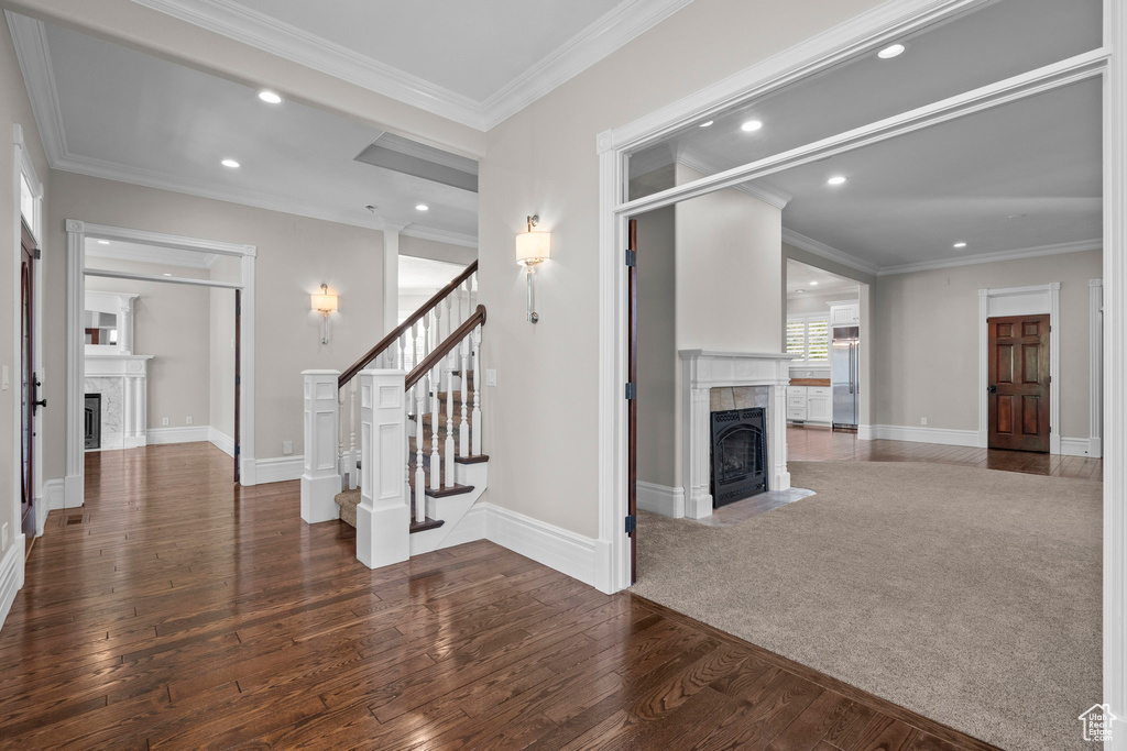 Unfurnished living room featuring a tiled fireplace, hardwood / wood-style flooring, recessed lighting, stairway, and baseboards