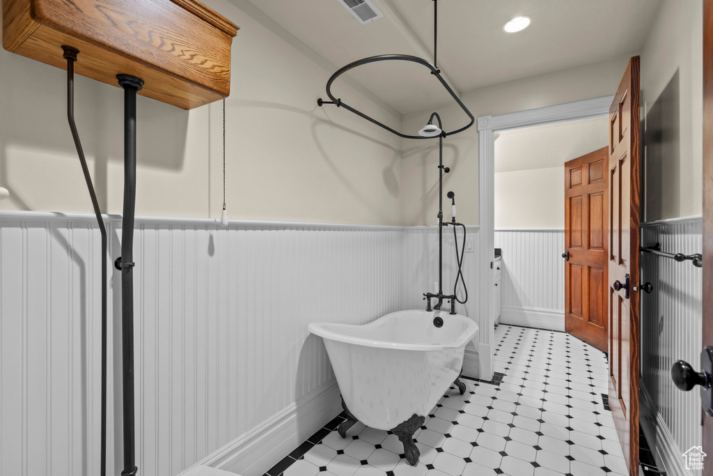 Full bath with wainscoting and a freestanding tub
