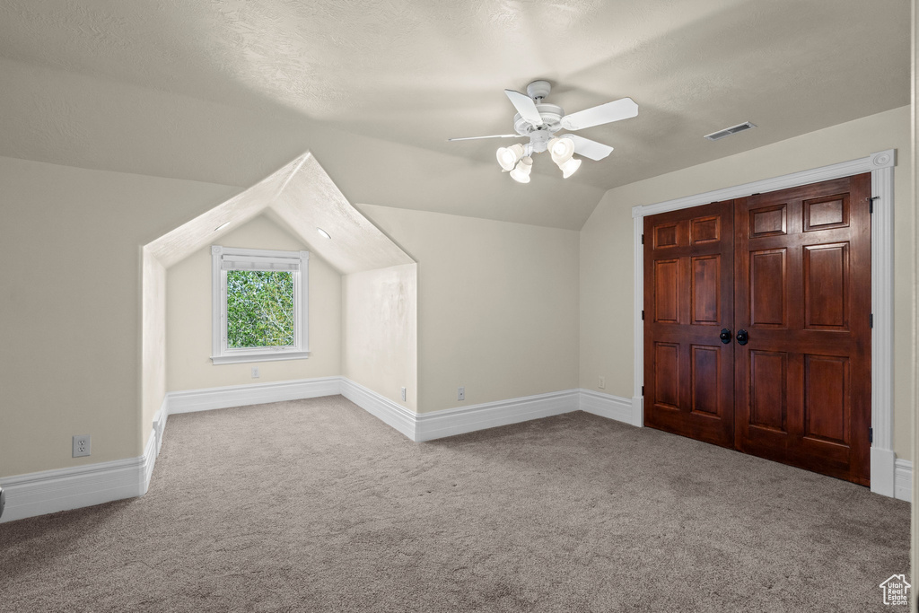 Additional living space with carpet floors, ceiling fan, lofted ceiling, and baseboards
