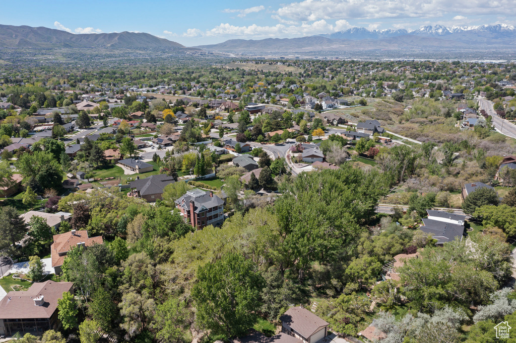 Aerial view of property and surrounding area with a mountain backdrop and nearby suburban area