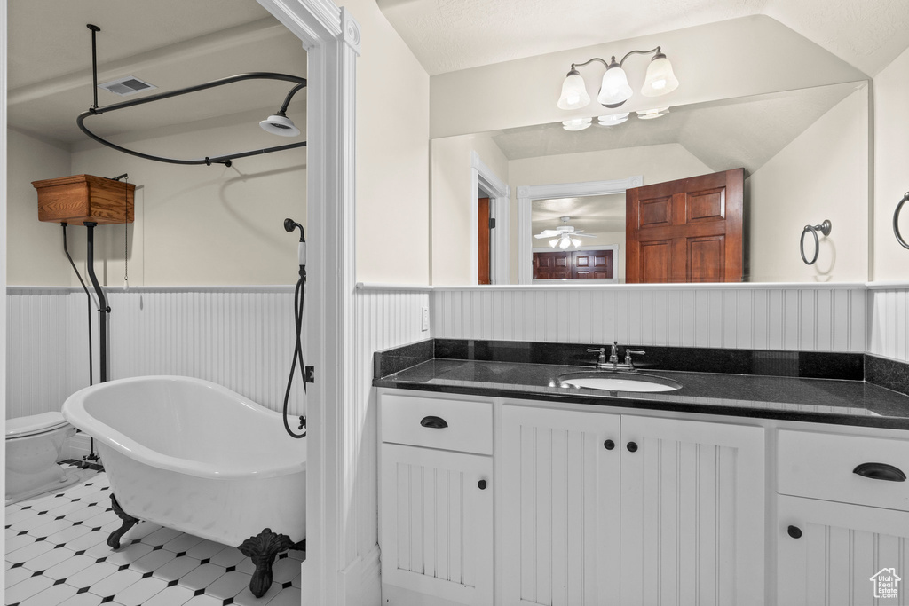 Full bathroom with wainscoting, a freestanding bath, vanity, and a ceiling fan