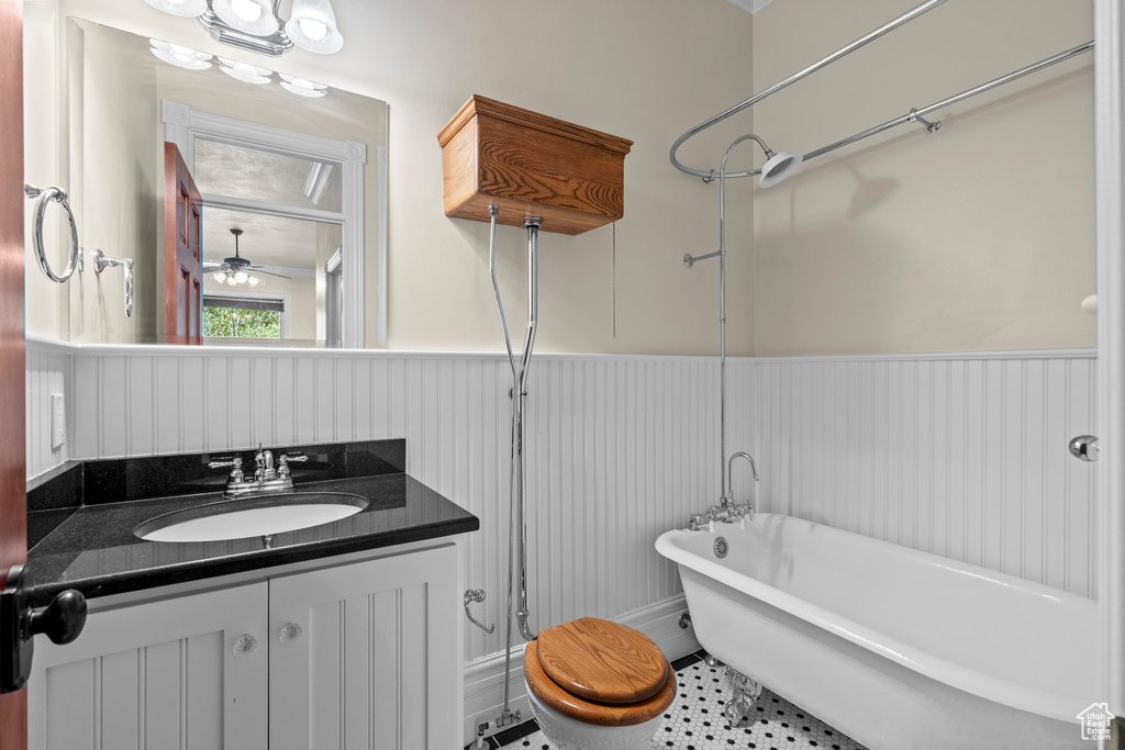 Bathroom with a wainscoted wall, a soaking tub, vanity, and ceiling fan