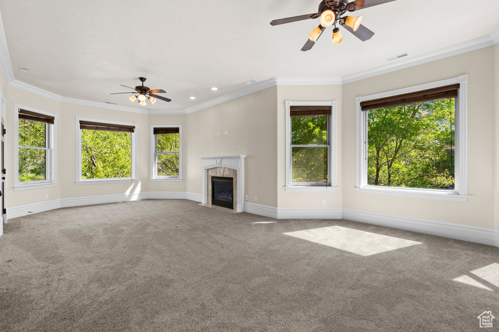 Unfurnished living room with a ceiling fan, plenty of natural light, carpet floors, ornamental molding, and recessed lighting