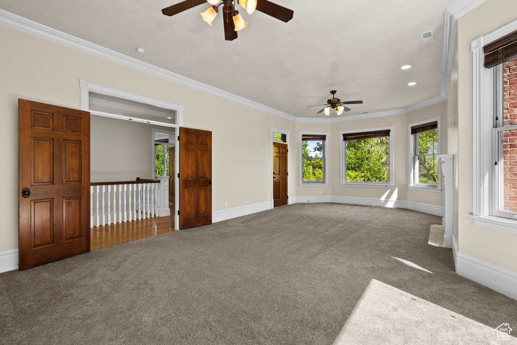 Carpeted spare room featuring a ceiling fan, crown molding, baseboards, and recessed lighting