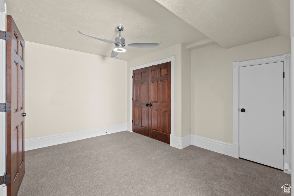 Unfurnished bedroom with carpet floors, baseboards, and a ceiling fan