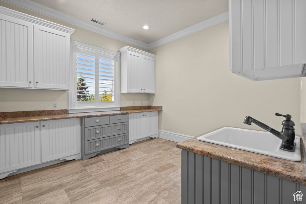 Laundry area with a sink, baseboards, ornamental molding, and recessed lighting