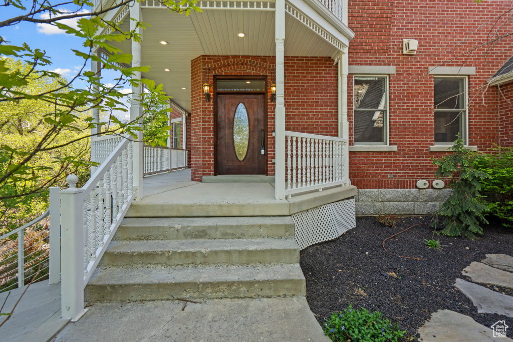 Entrance to property with brick siding and a porch