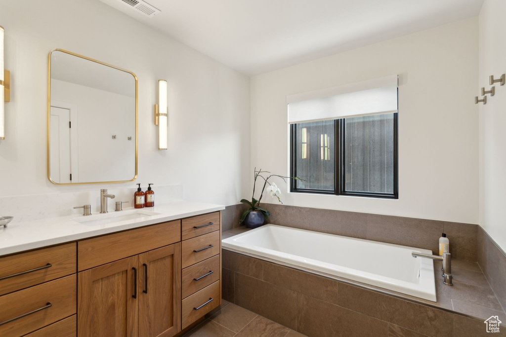 Full bathroom with vanity, a bath, and tile patterned floors