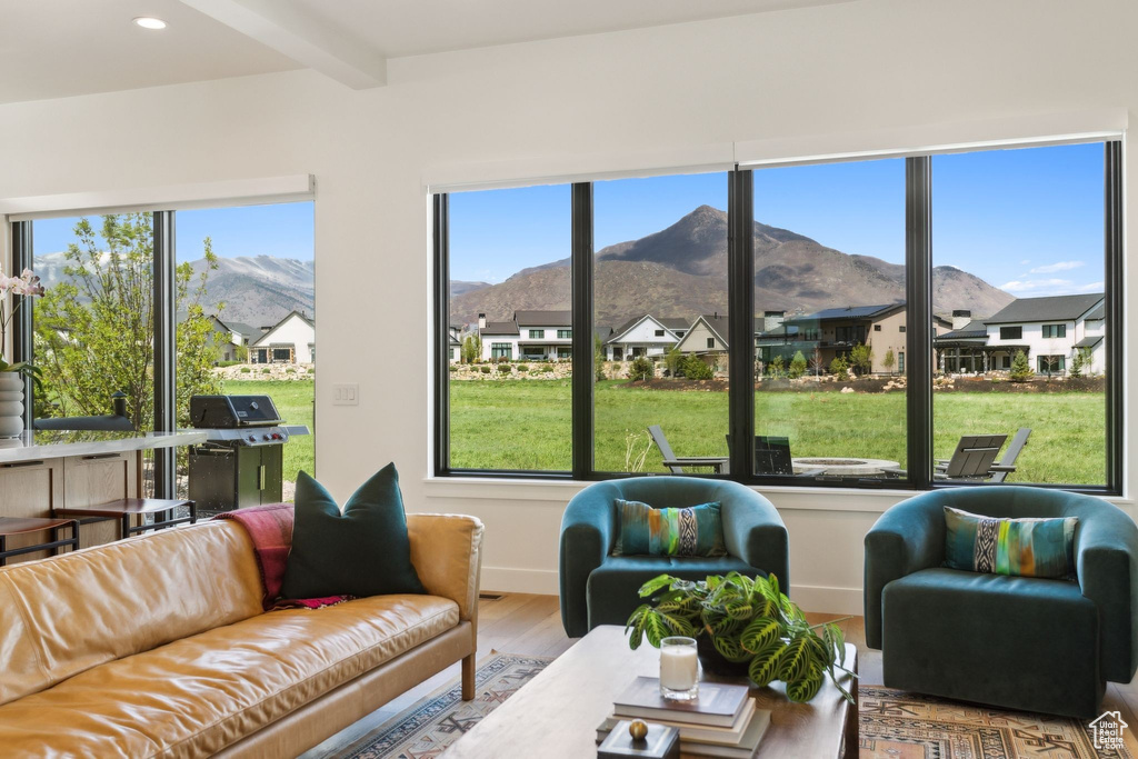 Sunroom with a mountain view, beamed ceiling, and a residential view
