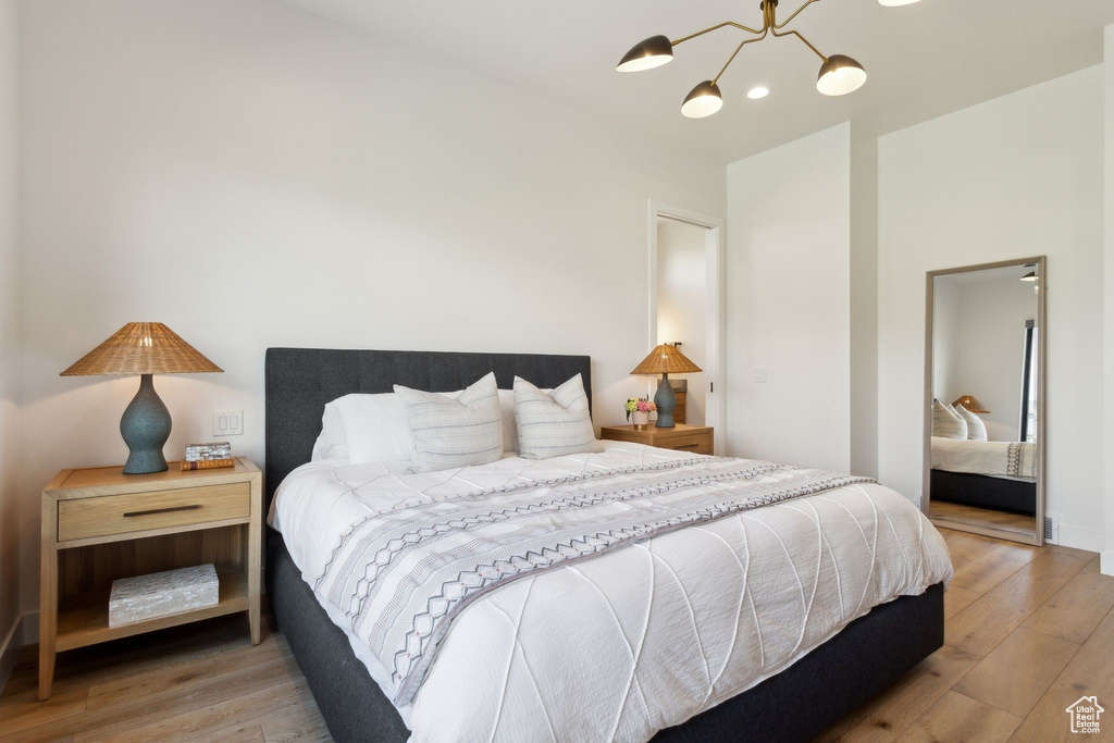 Bedroom with a chandelier and light wood finished floors