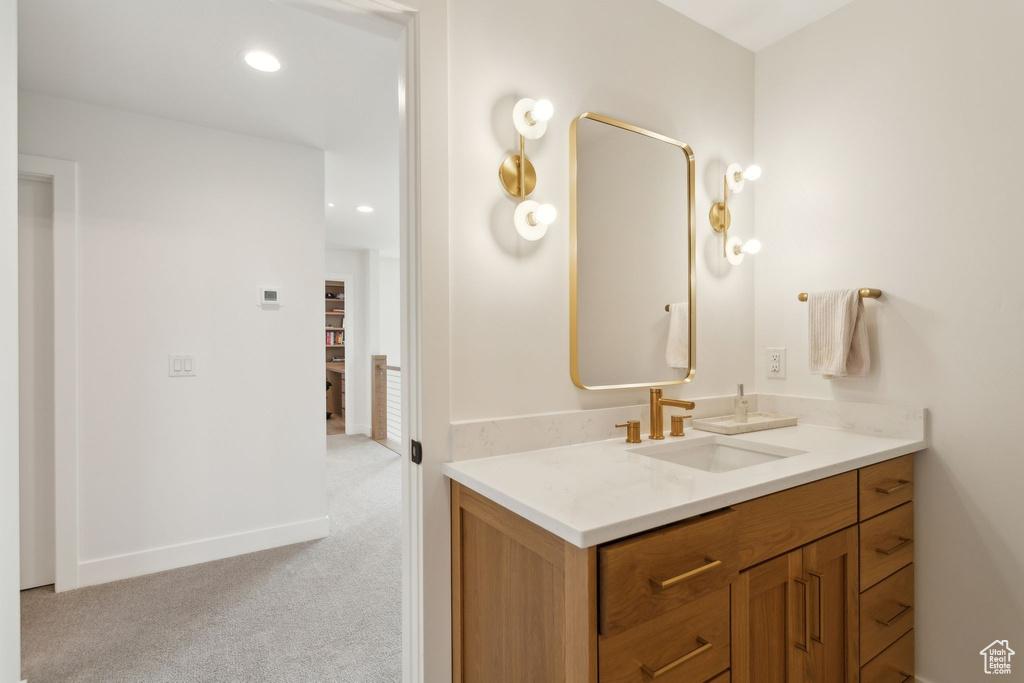 Bathroom featuring vanity, baseboards, and recessed lighting
